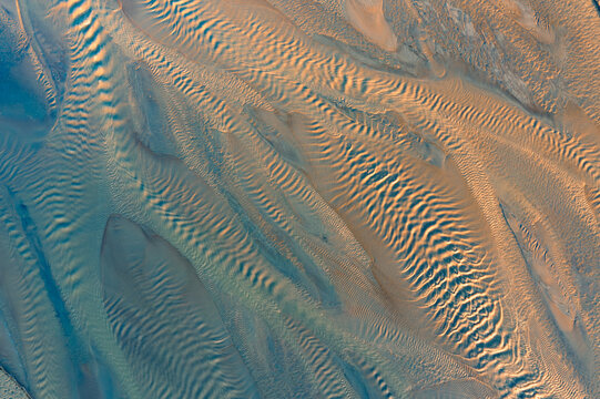 Aerial view of sediment abstract patterns and textures in the sand with ripples and golden light in Poland.