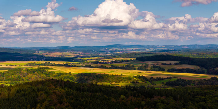 Aerial view of the rolling hills, patchwork fields, and dense forests of the rural landscape in Waldeck-Frankenberg, Hessen, Germany.