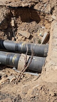 Underground pipe installation takes place at construction site on a sunny day