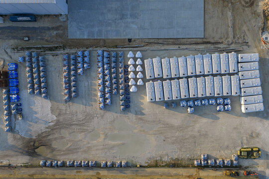 Aerial view of the CEMEX Pensacola Cement Import Terminal featuring rows of white storage silos and blue-covered pallets on an industrial site in Pensacola, Florida, United States.