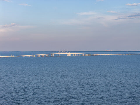 Aerial view of the Pensacola Bay Bridge spanning the calm blue waters of the bay under a clear sky in Gulf Breeze, Florida, United States.