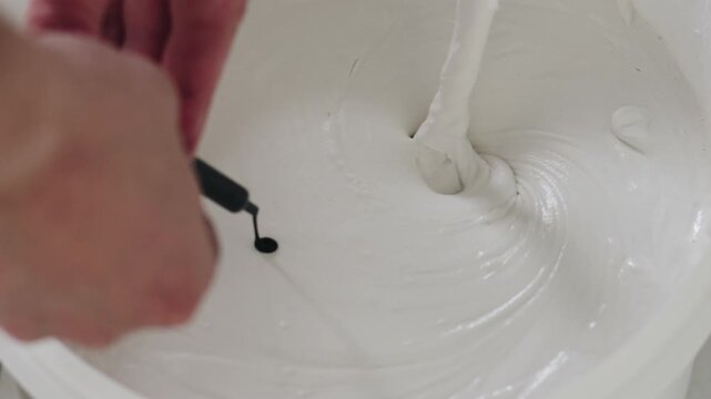 Slow motion closeup add black ink to decorative concrete plaster