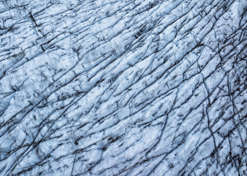 Aerial view of Svinafellsjokull Glacier showing deep blue ice crevasses and intricate glacial patterns in Svinafell, Sveitarfelagid Hornafjordur, Iceland.