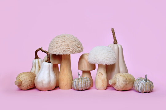 Decorative pumpkin and mushroom ornaments on pink background