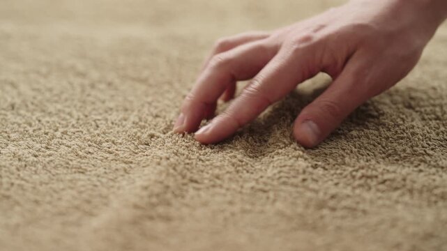 Slow motion closeup shot of man touching green cotton terry towel