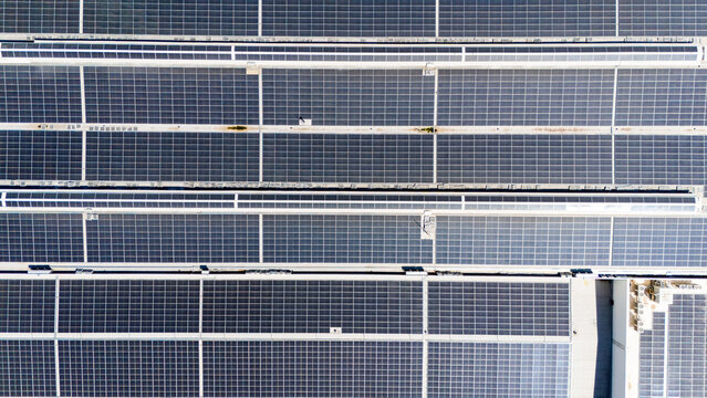 Aerial view of a large solar panel array installed on a flat industrial rooftop, showcasing rows of photovoltaic modules in Sabac, Vojvodina, Serbia.