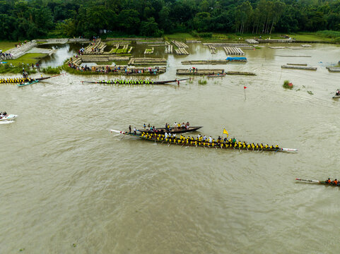 Aerial view of a traditional boat race with teams of rowers in long wooden boats on a river in Manikganj, Dhaka Division, Bangladesh.