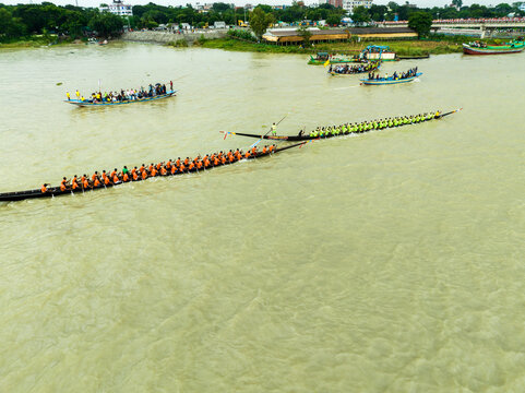 Aerial view of a traditional boat race with rowers in long narrow boats on the river in Manikganj, Dhaka Division, Bangladesh.