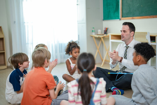 International school teacher leads circle time with diverse elementary students, encouraging children to share ideas and participate in group discussion.