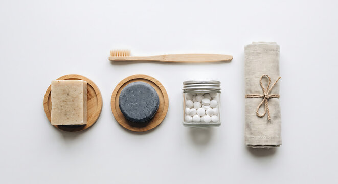 Eco-Friendly Bathroom Essentials: A thoughtfully curated collection of sustainable personal care items, including a bamboo toothbrush, natural soap, solid shampoo bar, and rolled towel.