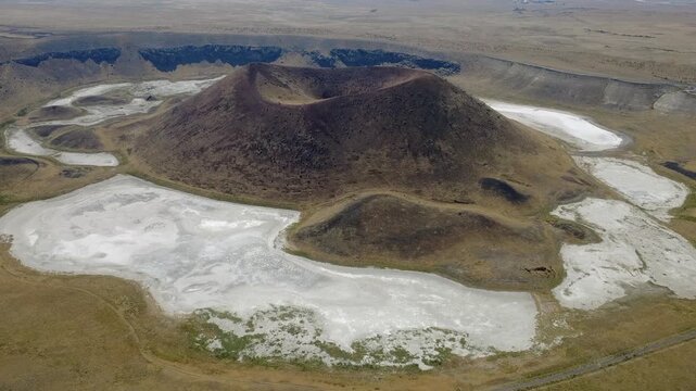 Aerial view of Meke Crater Lake cone and dry white salt lakebed in Karapinar, Konya, Turkey. Volcanic maar cone landscape captured with drone in 1080p.