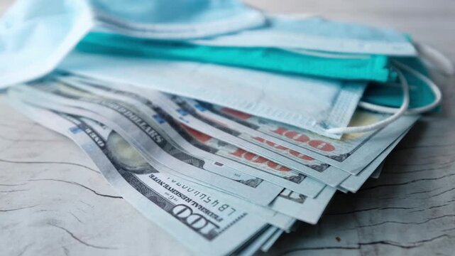 Medical masks on dollar bills close up, concept of healthcare costs and medical supplies on wooden table