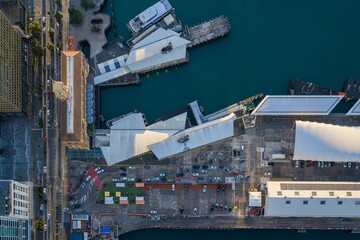Obraz premium Top-down aerial view of Queens Wharf in Auckland, New Zealand, showcasing waterfront architecture, docks and ferry terminals at sunrise.