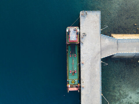 Aerial view of a cargo ship moored at the concrete pier of Waisai Harbour, Raja Ampat, Papua Barat Daya, Indonesia.