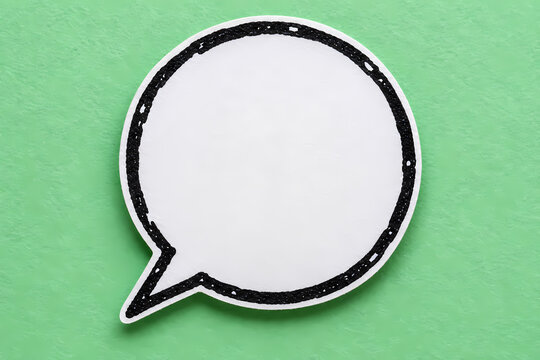 White blank circular speech bubble with a rough black outline and lower left tail on a mint green background, styled as a paper cutout comic chat icon with empty space for text