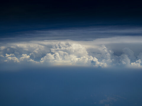 Aerial view of dense white cumulus clouds floating against a deep blue sky over Afghanistan.