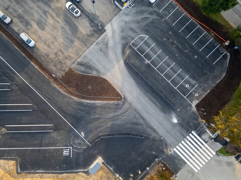 Aerial view of the Raksila parking lot featuring marked parking spaces, a taxi zone, and a pedestrian crosswalk on asphalt in Oulu, North Ostrobothnia, Finland.