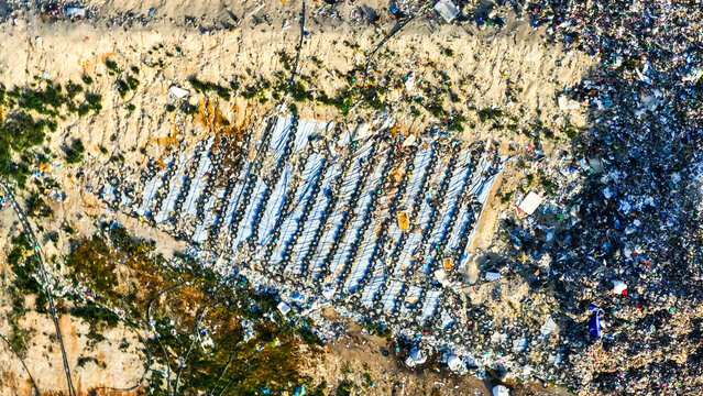 Aerial view of a landfill filled with mixed municipal waste, tires, and plastic debris highlighting environmental pollution and waste management in Portugal.