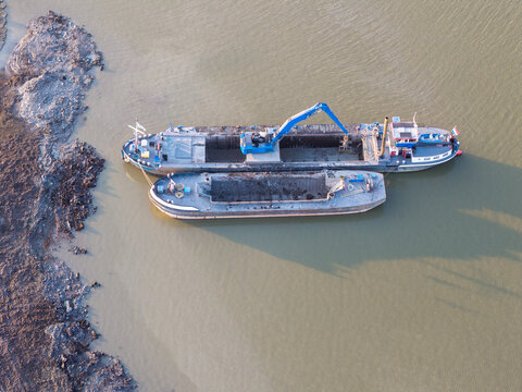 Aerial view of the dredger boat The Challenge working in the Alkmaardermeer with barges and a blue crane in Castricum, Noord-Holland, Netherlands.