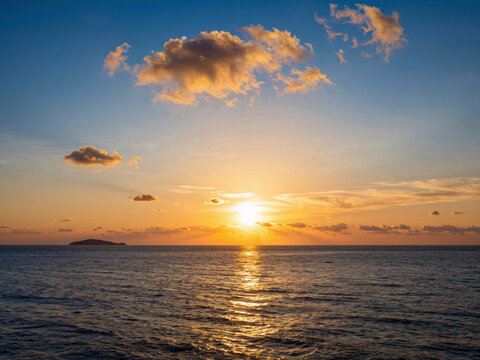 Silhouette of a small island on the sea during sunset
