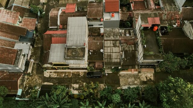 Aerial view of Mekarwangi residential area with dense housing, terracotta rooftops, narrow streets, and lush greenery in Tanah Sareal, West Java, Indonesia.