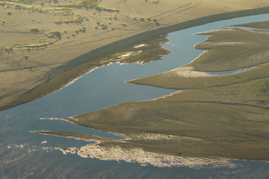 Aerial view of a river with low water levels exposing sandbanks and mudflats in the surrounding landscape in Poland.