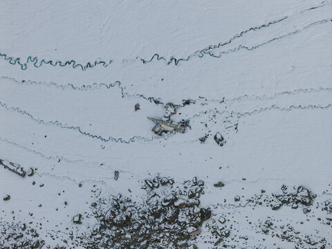 Aerial view of the wreckage of a C-124 Globemaster II at Bomber Glacier, surrounded by snow-covered terrain and glacial ice patterns, Matanuska-Susitna Borough, Alaska, United States.