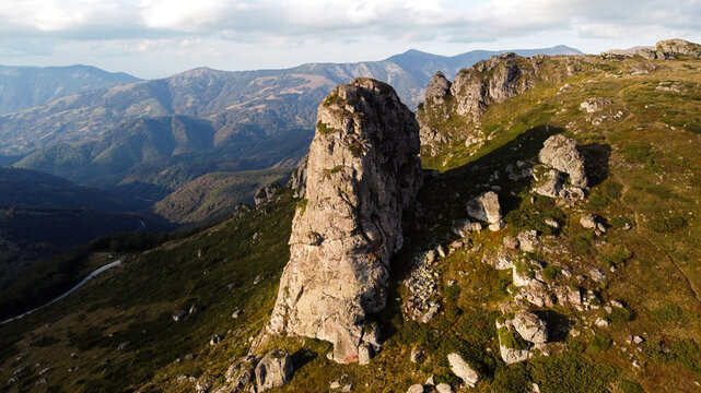 Aerial view of Babin Zub Peak in Stara Planina Mountain, Serbia, featuring steep slopes, scattered boulders, and distant mountain ranges in Gostusa, Pirot District, Serbia.
