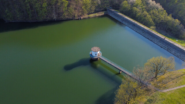 Aerial view of Bovan Lake featuring its distinctive water intake tower connected by a narrow walkway, surrounded by lush green trees and calm water in Sokobanja, Zajecar District, Serbia.