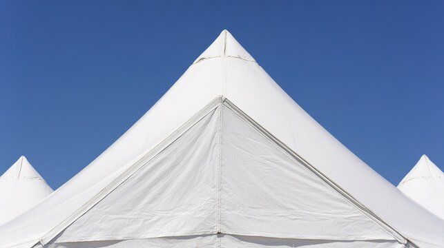 rigid. Geometric corner of a large white tent with triangular panels against blue sky. real-estate listings, architecture portfolios, designed for interior renovation comparisons for interiors.
