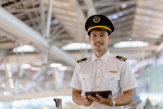 Asian steward or pilot man. Airline Airport service in uniform standing happy smiling in airport