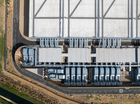 Aerial view of the Google Data Centre in Waltham Cross, featuring extensive rooftop HVAC infrastructure, cooling units, and surrounding asphalt access roads in Cheshunt, England, United Kingdom.