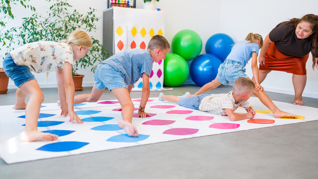 Kids practice mental arithmetic on a floor abacus with their teacher, combining counting with physical movement, concentration and coordination.