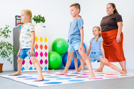 Kids practice mental arithmetic on a floor abacus with their teacher, combining counting with physical movement, concentration and coordination.