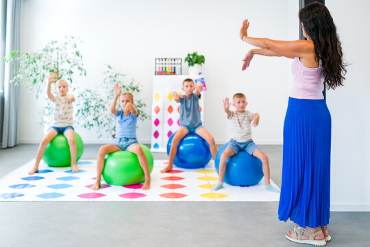 Kids practice mental arithmetic using abacus gestures while performing motor exercises on balance balls, combining calculation, movement, concentration and coordination.