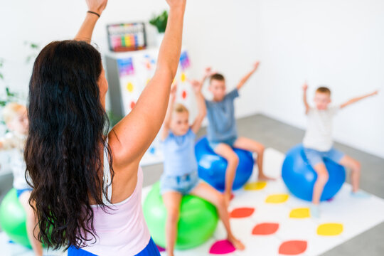Kids practice mental arithmetic using abacus gestures while performing motor exercises on balance balls, combining calculation, movement, concentration and coordination.