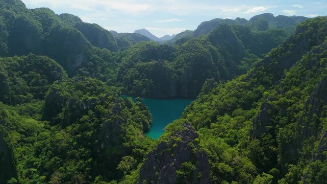 Aerial drone footage showing stunning tropical lagoon surrounded by limestone cliffs in Coron Palawan Philippines.