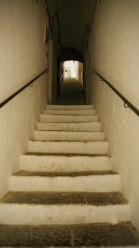 Whitewashed stairway leading up through a dim vaulted passage in Amalfi