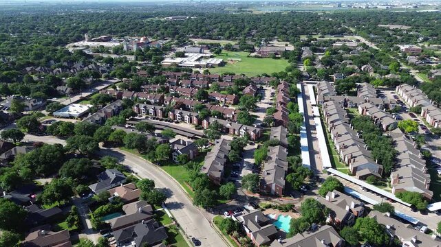 Residential subdivisions border Parkway Boulevard beside Saint Ann Catholic Parish grounds. Curved avenues, sparkling community swimming pools, shaded parking bays frame Coppell, Texas.