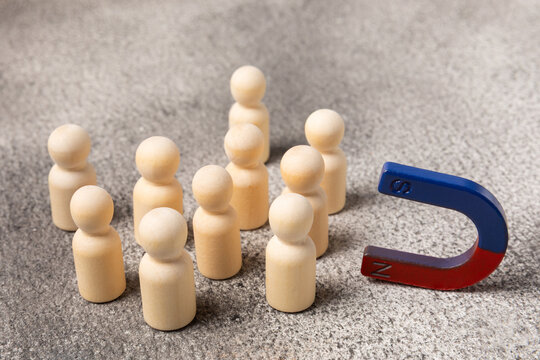 Magnet attracting human figures, concept of leadership, teamwork, social connection, cooperation and attraction of people. Magnet for your customers, clients or human resources. Marketing and manageme