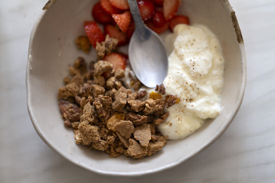 Bol de petit-d&eacute;jeuner sain avec yaourt, granola croquant et fraises fra&icirc;ches