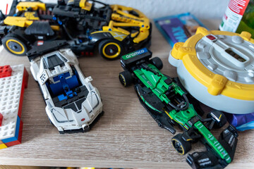 Obraz premium Warsaw, Poland - Sep 4, 2026: LEGO Technic model cars and construction vehicle displayed on a wooden shelf