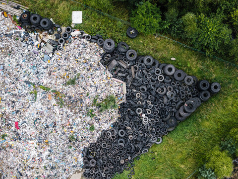 Aerial view of a landfill site with a massive pile of discarded rubber tires and mixed consumer waste, highlighting environmental pollution in Laidzes pagasts, Talsu novads, Latvia.