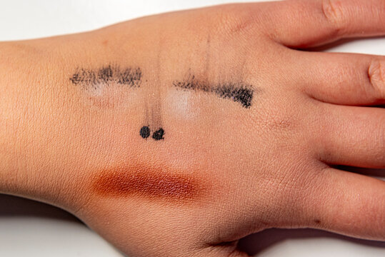 Close-up einer Kinderhand mit aufgemaltem, stilisiertem Gesicht