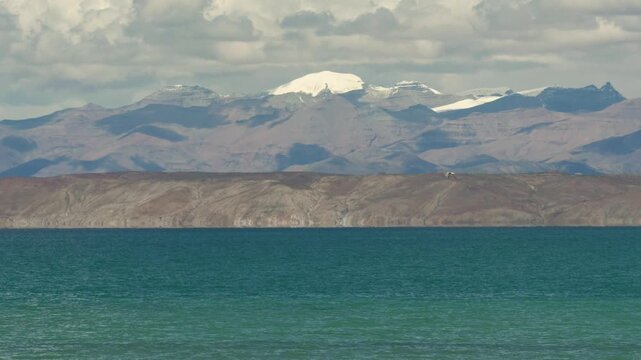 Bird fly in sky with snow mountains green lake background, beautiful landscape of Mapam Yumco or Lake Manasarovar&zwnj; in Purang, Ngari, Xizang, China. 4k slow motion footage travel concept b roll shot.