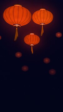 Vertical video of red paper lanterns with golden tassels glowing and swaying in the night, blurred lights behind, seamless loop with copy space