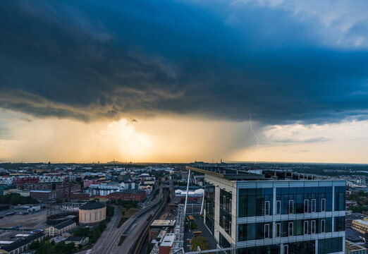 Aerial view of Kalasatama towers during a dramatic thunderstorm with a lightning strike hitting the city skyline under dark clouds at golden hour in Helsinki, Uusimaa, Finland.