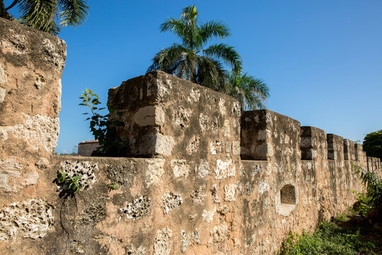 Ancient Stone Fortress Wall with Crenellations Under Blue Sky