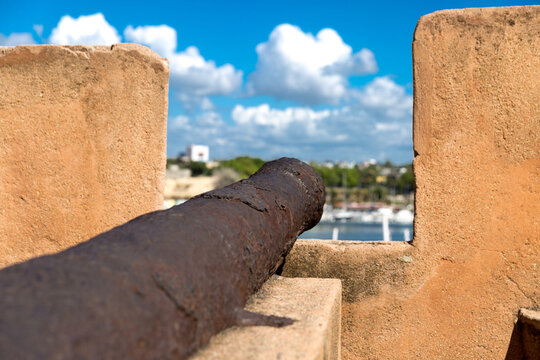 Ancient Rusty Cannon on Fortress Wall Overlooking Harbor