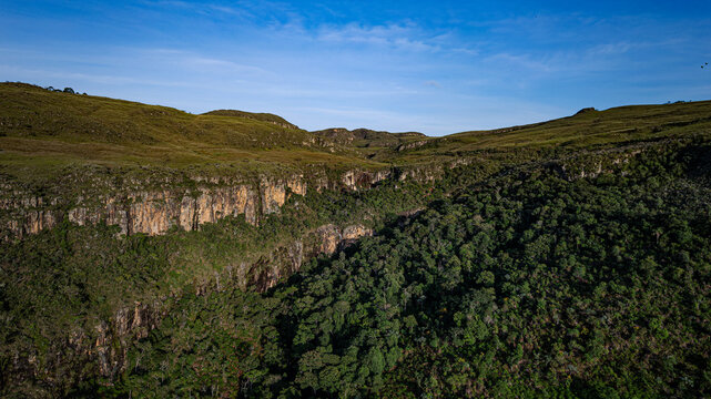Aerial view of Serra da Canastra canyon with rocky cliffs and dense green vegetation under a clear blue sky in Sao Roque de Minas, Minas Gerais, Brazil.